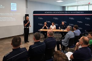 Na zdjęciu widać przemawiającego policjanta oraz osoby biorące udział w spotkaniu