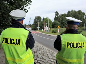 dwaj policjanci obserwują ruch w rejonie przejazdu kolejowego