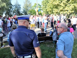 policjant stoi przed grupą osób podczas koncertu Powiatowy Blues