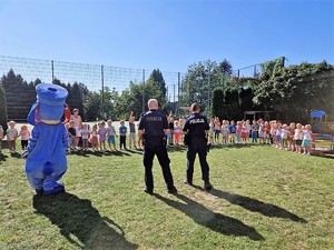 na zdjęciu obok policjantów stoi maskotka śląskiej policji, pies Sznupek