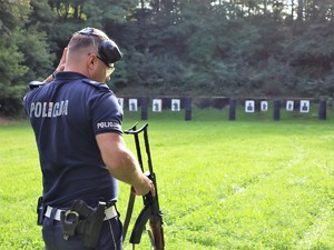 policjant przygotowuje się do strzelania z broni długiej