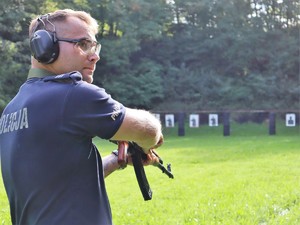 policjant przygotowuje się do strzelania z broni długiej