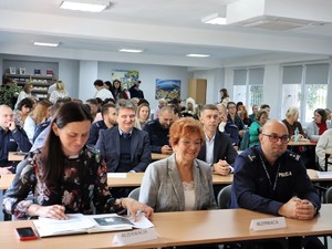 na sali w ławkach siedzą uczestnicy debaty społecznej, w tym Wicestarosta, Naczelnik Wydziału Edukacji Starostwa Powiatowego i Komendant Powiatowy Policji w Wodzisławiu Śląskim