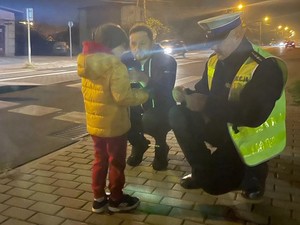 policjant wręcza odblask ojcu z dzieckiem