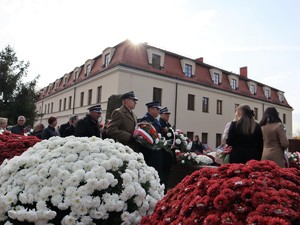 przedstawiciele służb trzymają kwiaty biało - czerwone, trwa uroczystość pod Pomnikiem Powstańców Śląskich