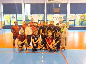 policjanci w strojach sportowych pozują do wspólnego zdjęcia z drużyną uczniów