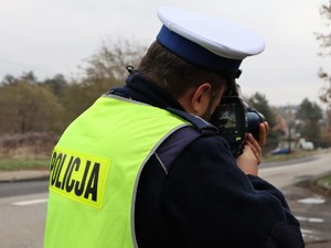 policjant mierzy urządzeniem prędkość, z jaką poruszają się pojazdy