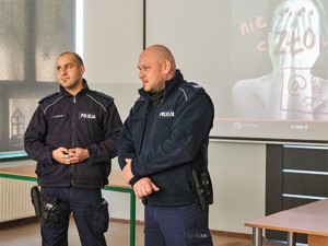 policjanci stoją obok siebie, prowadzą spotkanie profilaktyczne z młodzieżą