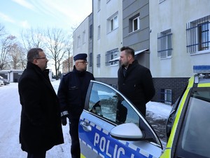 samorządowcy oglądają nowo zakupiony policyjny radiowóz, prezentuje go Komendant Powiatowy