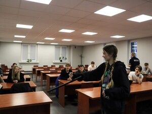 na sali odpraw siedzą praktykanci, dziewczyna trzyma w ręku policyjną palkę służbową