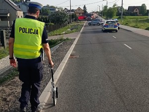 policjant wykonuje czynności na miejscu wypadku drogowego