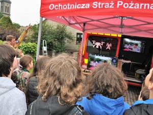 dzieci obserwują monitory na których wyświetla się obraz nagrany dronem