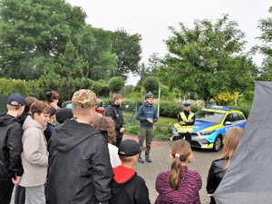 policjantka i ksiądz stoją na przeciwko młodzieży, rozmawiają z nimi