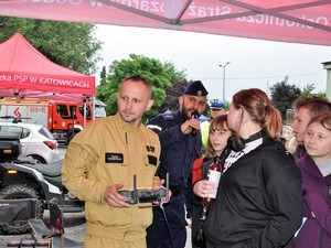 strażak trzyma pilot od droga, przyglądają się mu dzieci