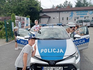 policjant prezentuje dzieciom radiowóz podczas festynu