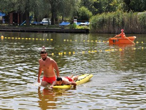 ratownik wodny holuje pozoranta na desce