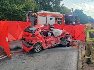 na zdjęciu widać miejsce wypadku drogowego, widać uszkodzony samochód i pojazdy służb