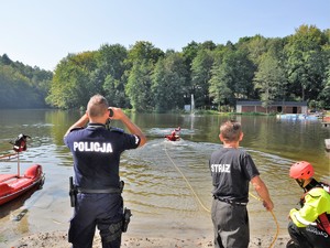 trwa pokaz ratownictwa wodnego, obok stoi policjnat