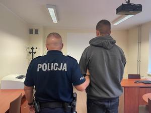 policjant trzyma za ramię zatrzymanego nastolatka