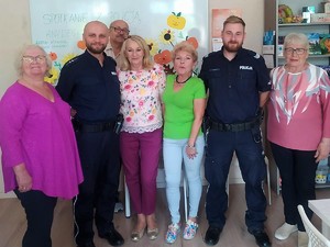 policjanci pozują do wspólnego zdjęcia razem z seniorami