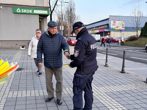 policjant wręcza mężczyźnie odblask