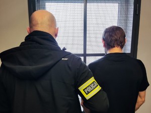 policjant trzyma zatrzymanego mężczyznę