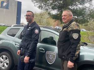 policjant stoi obok funkcjonariusza Straży Rybackiej