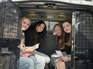 w policyjnym radiowozie, w części z kratami do zdjęcia pozują nastolatki