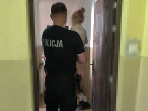 na zdjęciu widać policjanta, który trzyma na ręku małą dziewczynkę
