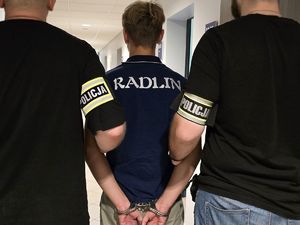 dwaj nieumundurowani policjanci trzymają zatrzymanego mężczyznę