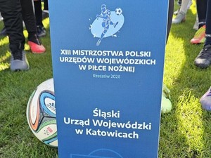 na zdjęciu widać bilbord przedstawiający drużynę Śląskiego Urzędu Wojewódzkiego podczas turnieju piłki nożnej