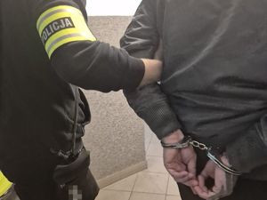policjant prowadzi zatrzymanego mężczyznę