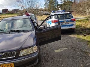 Na zdjęciu widać zatrzymany do kontroli pojazd i stojący obok radiowóz.