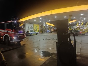 na zdjęciu widać policyjny radiowóz oraz wóz strażacki stojące na stacji benzynowej